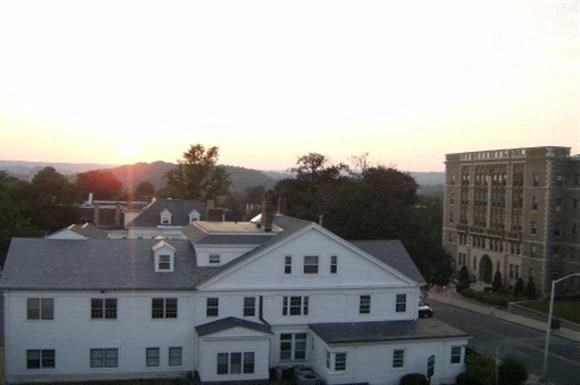 a view of a large white house and a tall building