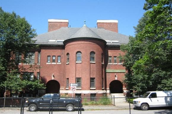 a brick building with cars parked in front of it