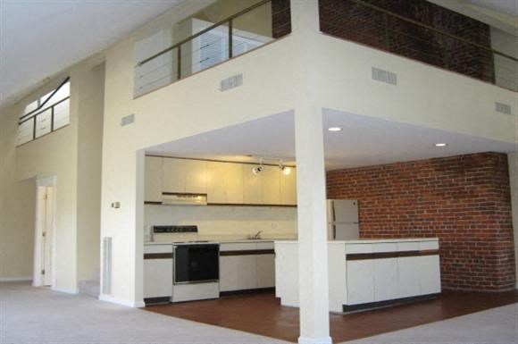 an empty kitchen with a brick wall