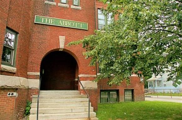 a red brick building with a green sign on top of it