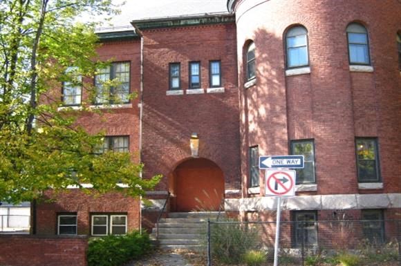 a red brick building with a no parking sign