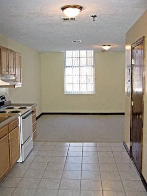 an empty kitchen with a stove and a window