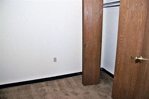 two wooden doors in a room with a white wall