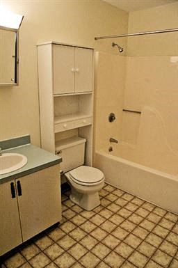 a bathroom with a toilet and a sink and a shower