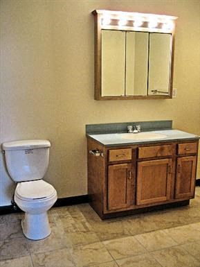 a bathroom with a toilet and a sink and a mirror
