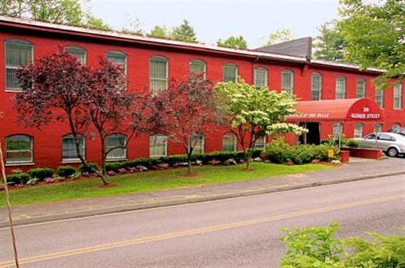 a red building with trees in front of a street
