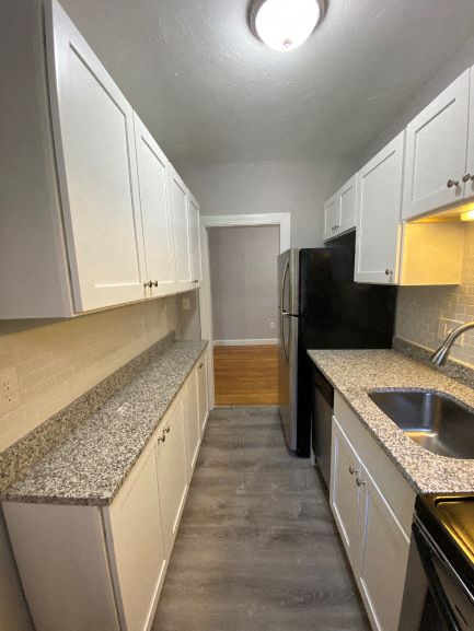 Kitchen with granite counters, white cabinets and stainless appliances