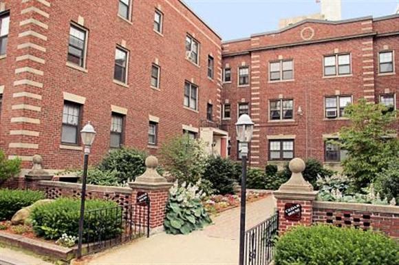 a red brick building with a garden in front of it