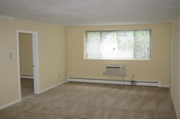 an empty room with a window and a radiator