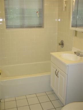 a white bathroom with a sink and a bath tub