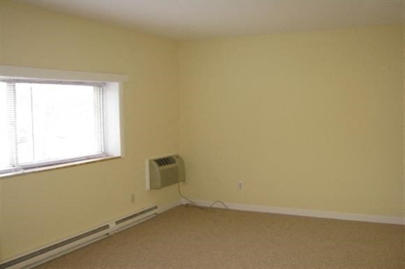 an empty room with a heater and a window