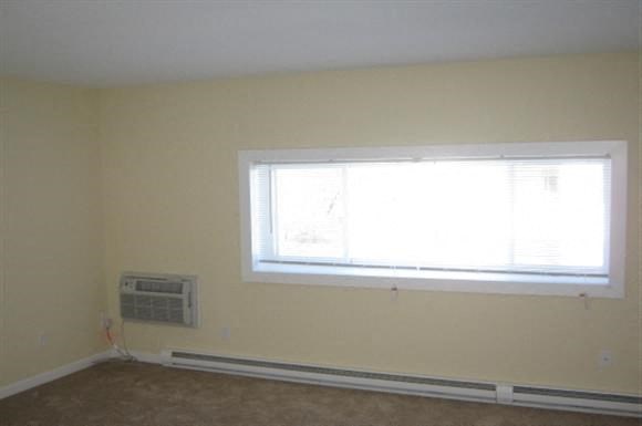 an empty room with a window and a air conditioner