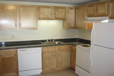 a kitchen with white appliances and wooden cabinets