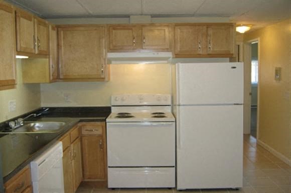a kitchen with white appliances and wooden cabinets