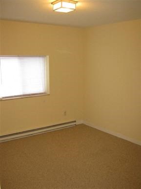 an empty room with a window and a carpet