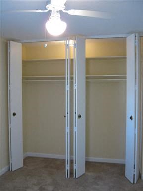an empty room with a closet and a ceiling light