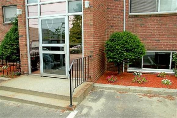 a brick building with a glass door and stairs