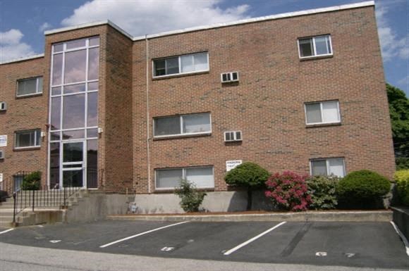a brick building with a parking lot in front of it