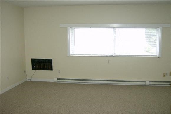 an empty room with a window and a radiator