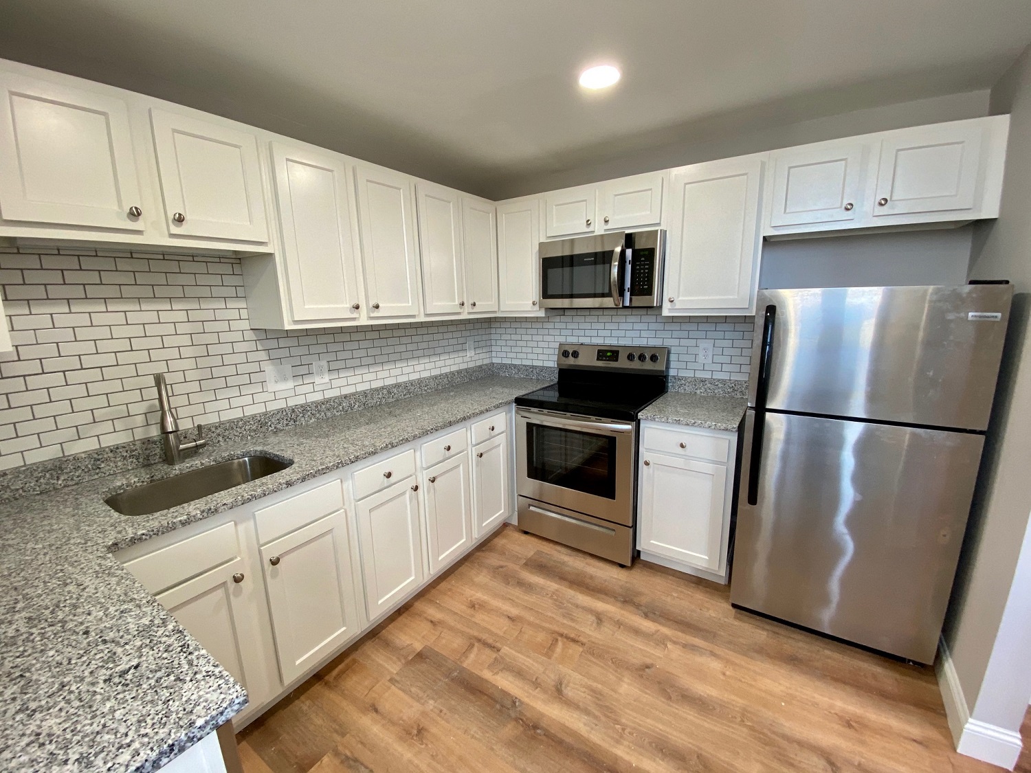a kitchen with white cabinets and stainless steel appliances
