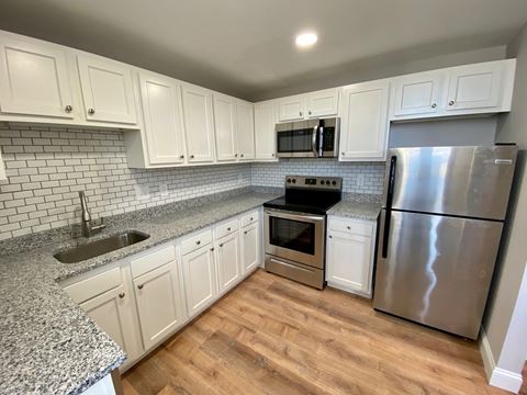 Renovated Kitchen with white cabinets, granite counters and laminate floors