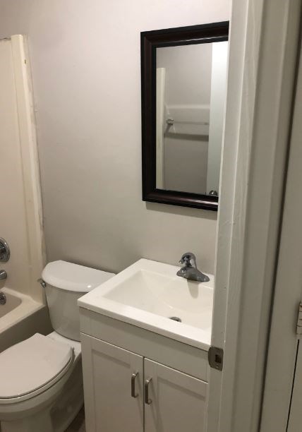 a bathroom with a toilet and a sink and a mirror