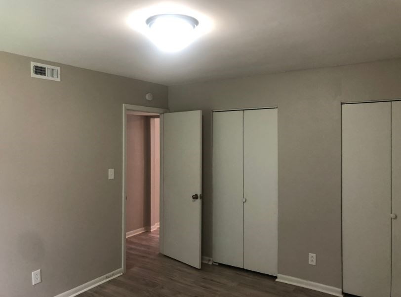 a room with three closets and a light on the ceiling