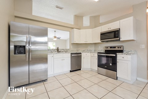 a large kitchen with stainless steel appliances and white cabinets
