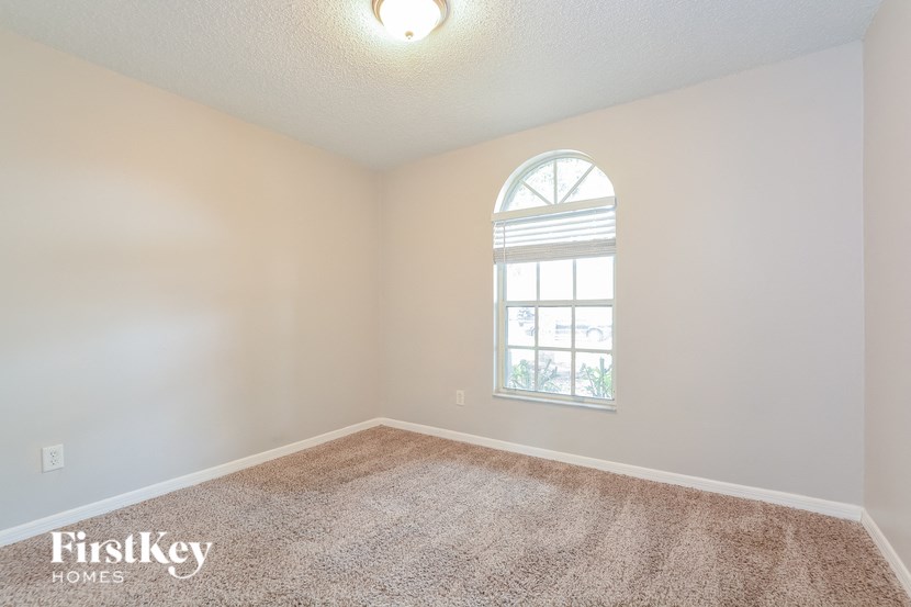 an empty room with a window and carpet