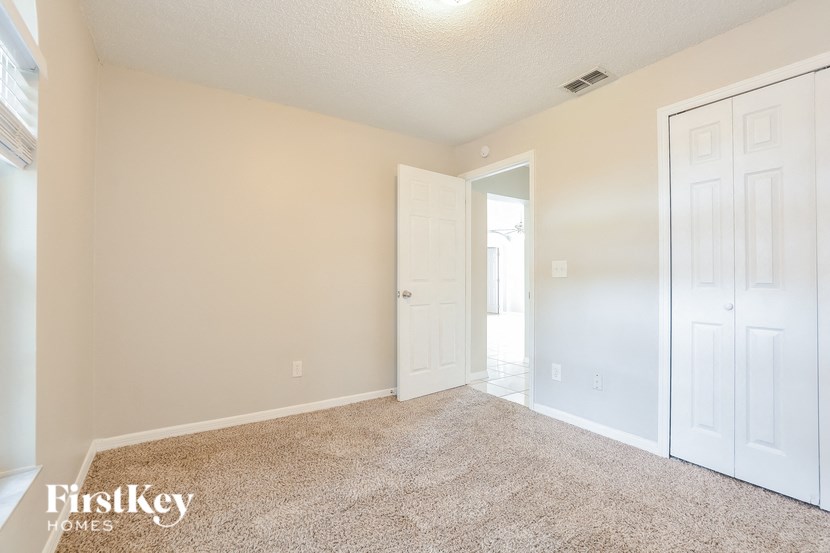 the living room and entrance to a bedroom with white doors