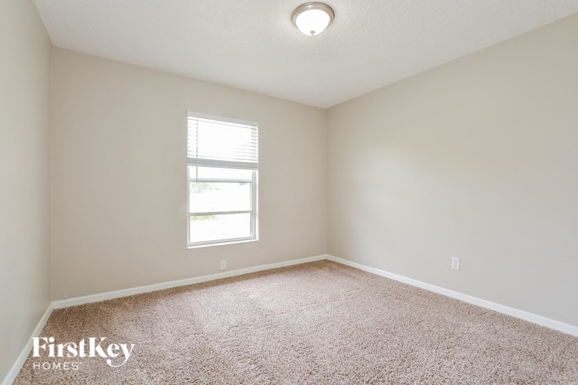 an empty room with a window and a carpet