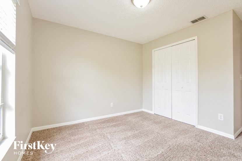 an empty living room with a door to a closet