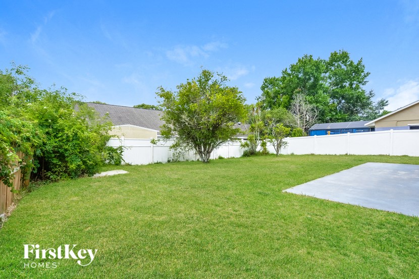 a backyard with a yard and a white fence