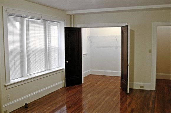 an empty living room with a wooden floor and a door