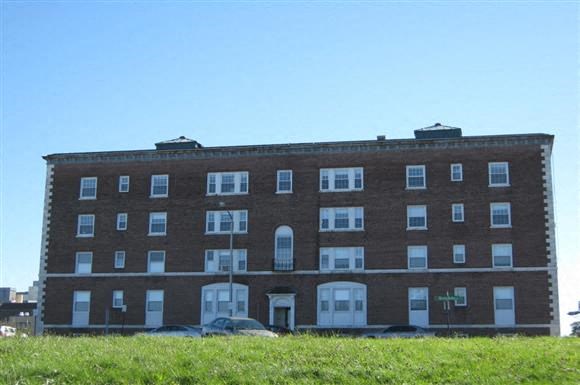 a large brick building with cars in front of it