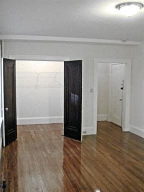 an empty living room with wood floors and a door