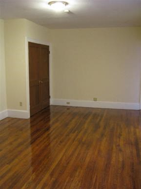an empty living room with a wooden floor and a door
