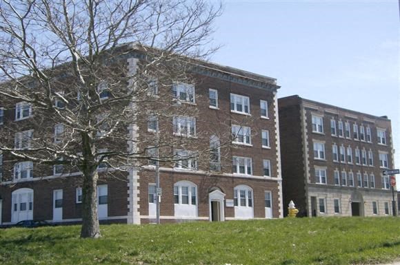 a large brick building with a tree in front of it