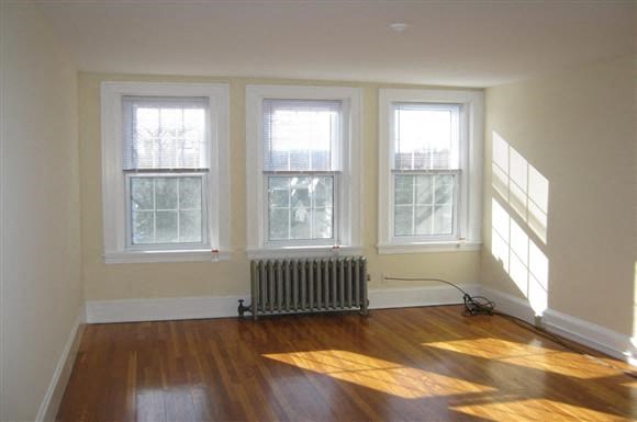 a living room with a heater and three windows