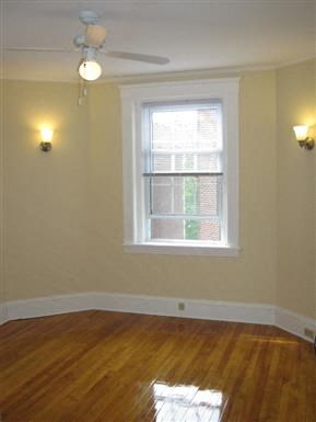an empty room with a window and a ceiling fan