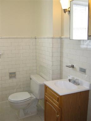 a white bathroom with a toilet and a sink