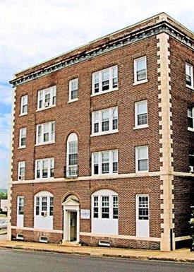 a red brick building with white doors and windows