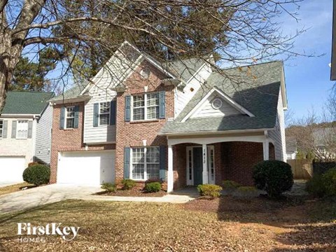a brick house with a white garage and a tree
