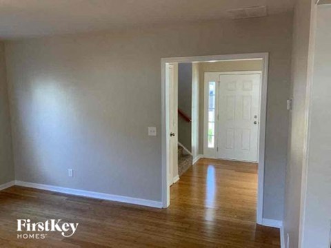an empty living room with wood floors and a white door