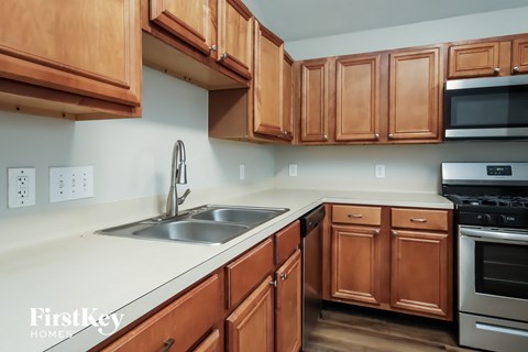 A kitchen with wooden cabinets and a stainless steel sink.
