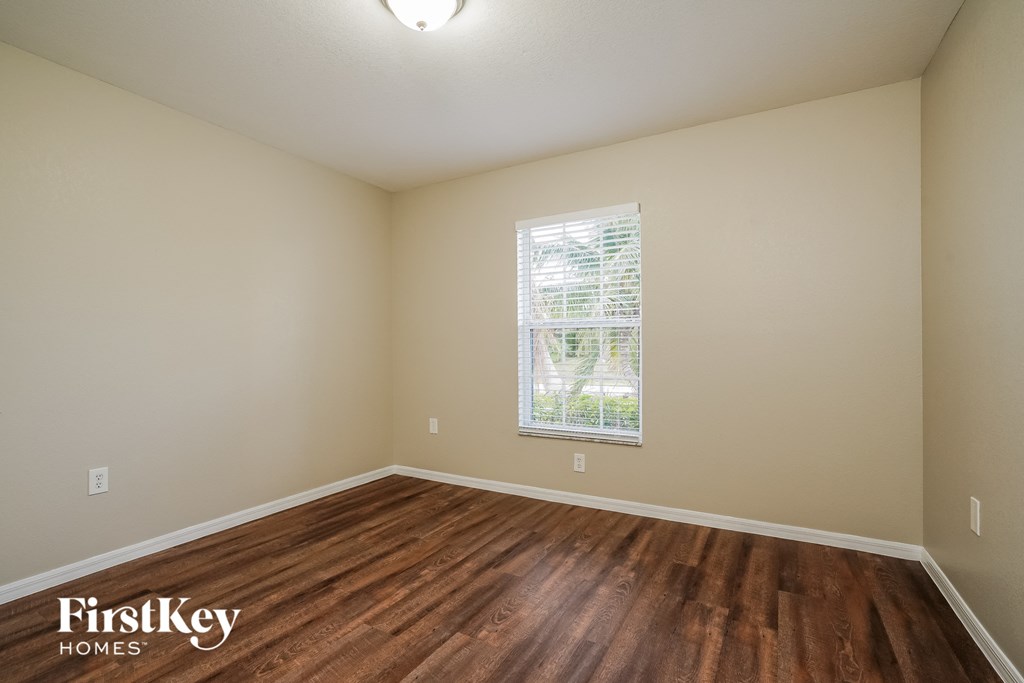 the spacious living room with hardwood flooring and a window