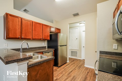 a kitchen with granite counter tops and a stainless steel refrigerator