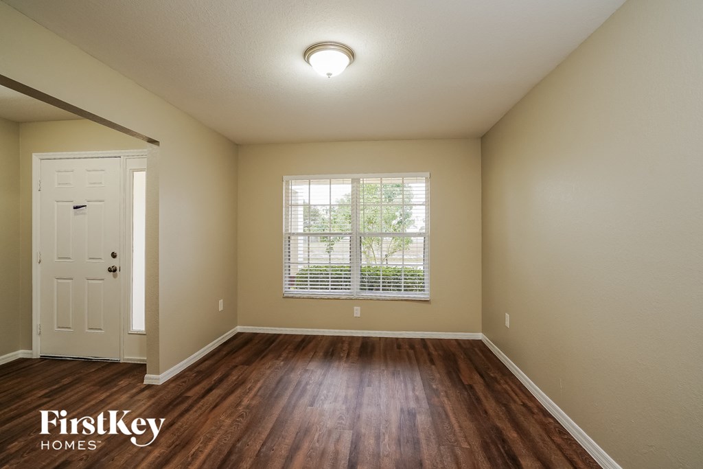 the spacious living room with hardwood flooring and a large window