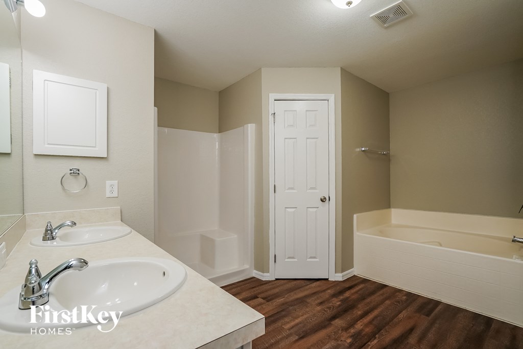 a bathroom with a sink and a tub and a white door