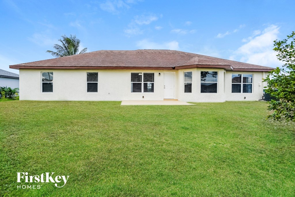 a white house with a green lawn and a blue sky